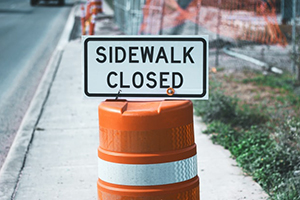 construction sign that says a sidewalk is closed